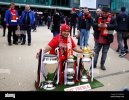 a-manchester-united-fan-poses-for-a-photo-with-the-treble-trophies-outside-the-stadium-before-...jpg